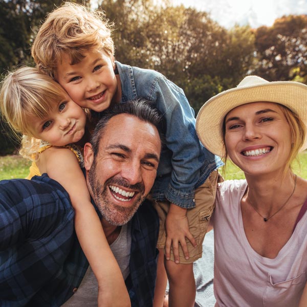 A joyful family poses for a selfie in a vibrant park in Flagstaff and Cottonwood, AZ.