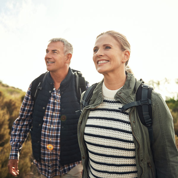 A man and woman hiking together on a scenic trail surrounded by nature in Flagstaff and Cottonwood, AZ