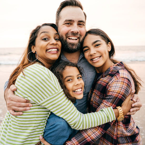 couple with teenage girls at the beach