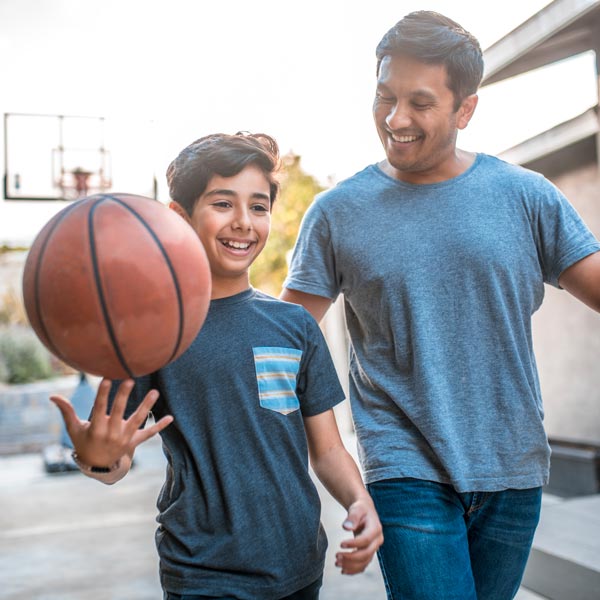 Father and son engaged in a lively outdoor basketball game in Flagstaff and Cottonwood, AZ.