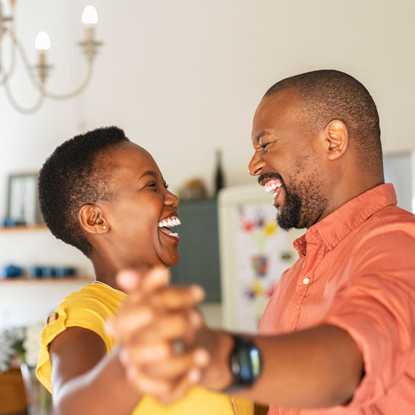 adult couple smiling and dancing in home