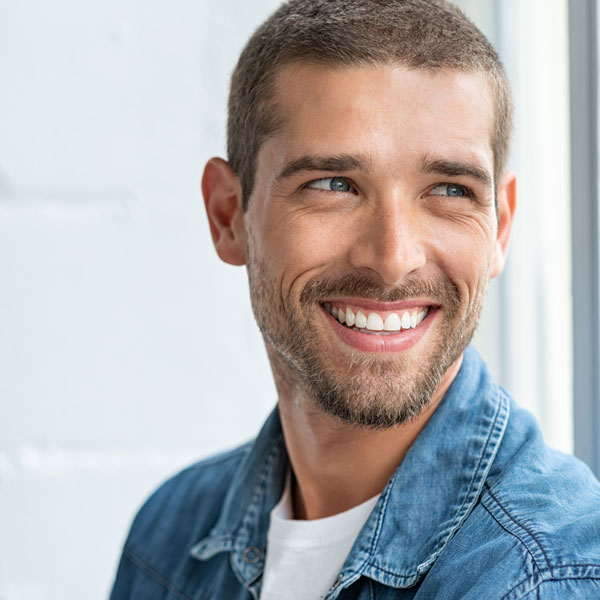adult man with jean jacket smiling